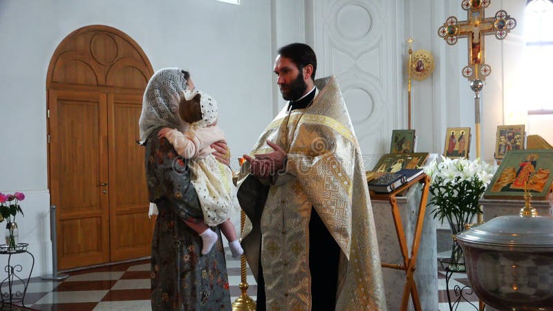 The priest in the church tells the canons of the mother with the child in his arms