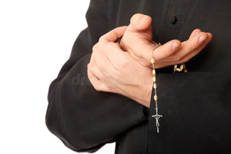 Priest's hands with rosary stock photo