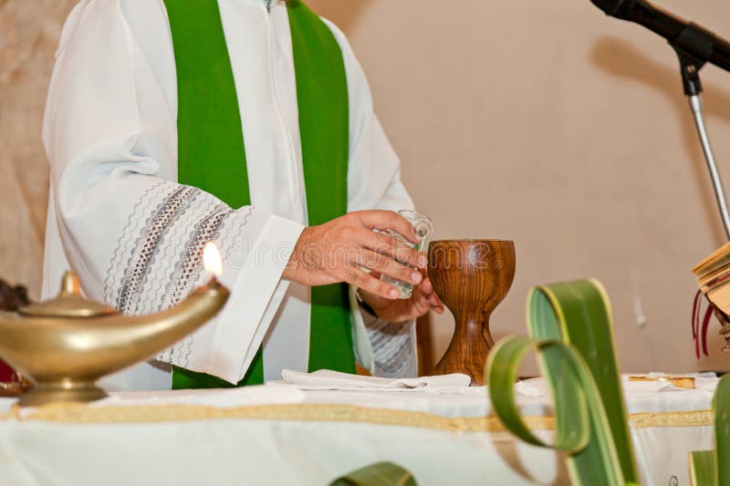 Priester in grünem Chabel, um den Kalice bereit für heilige Masse in der Kirche lizenzfreies stockfoto