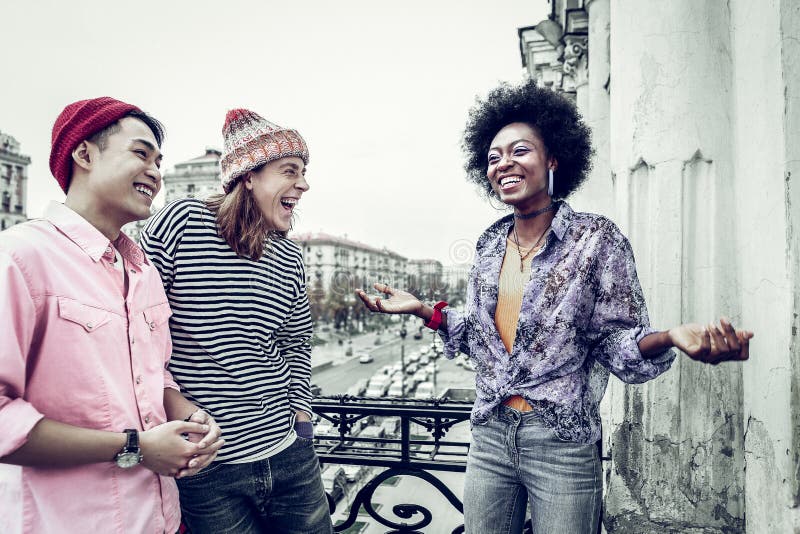 Prieteni veseli și rasiști râzând de glumă stock photography
