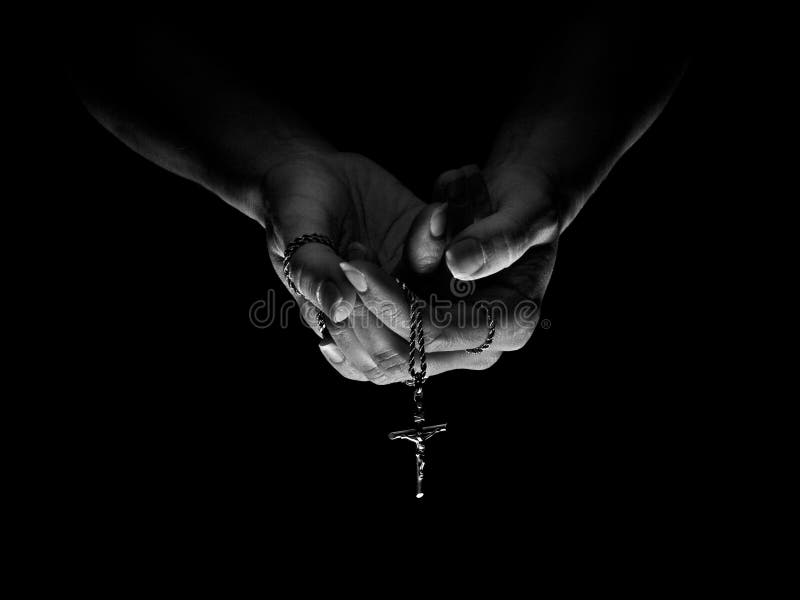 A woman praying with a crucifix. A woman praying with a crucifix