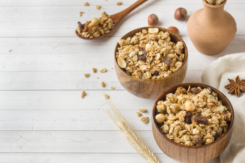 Prima colazione asciutta dei fiocchi, dei granelli e dei dadi dell'avena Muesli in un piatto di legno profondo