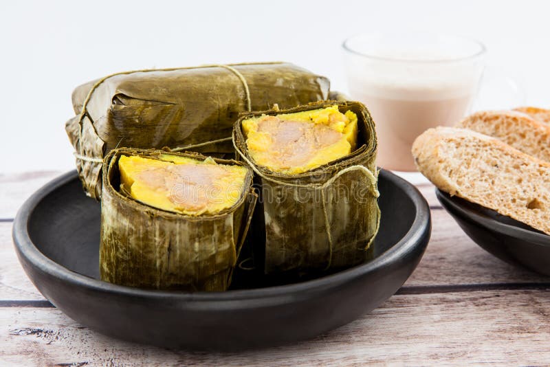Prima colazione colombiana tradizionale del tamale con pane e cioccolato come fatto sulla regione di Santander fotografia stock Prima colazione colombiana tradizionale del tamale con pane e cioccolato come fatto sulla regione di Santander fotografia stock