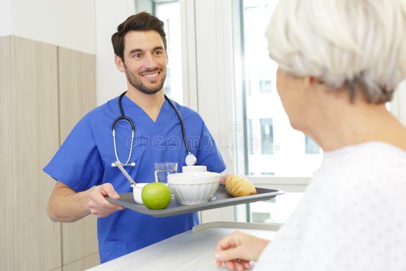Prima colazione del servizio dell'infermiere al paziente in ospedale fotografie stock libere da diritti Prima colazione del servizio dell'infermiere al paziente in ospedale fotografie stock libere da diritti