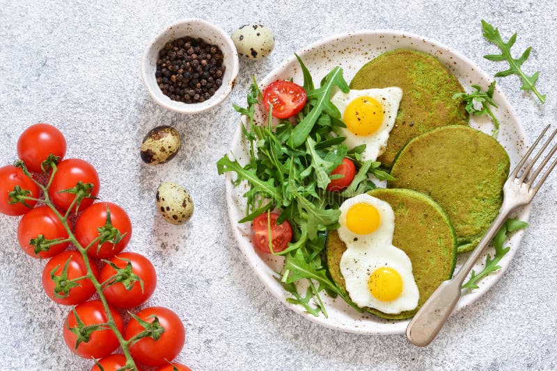 Prima colazione di mattina: pancake con spinaci, insalata e l'uovo sul tavolo da cucina fotografie stock libere da diritti Prima colazione di mattina: pancake con spinaci, insalata e l'uovo sul tavolo da cucina fotografie stock libere da diritti