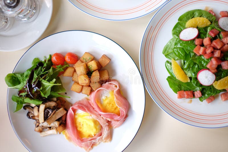 Prima colazione messa - uova Benedict ed insalata immagine stock libera da diritti Prima colazione messa - uova Benedict ed insalata immagine stock libera da diritti