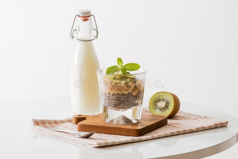 Prima colazione sana con i semi del yogurt, del dado, del kiwi e di chia Ciotola di frutta fresca fotografia stock Prima colazione sana con i semi del yogurt, del dado, del kiwi e di chia Ciotola di frutta fresca fotografia stock