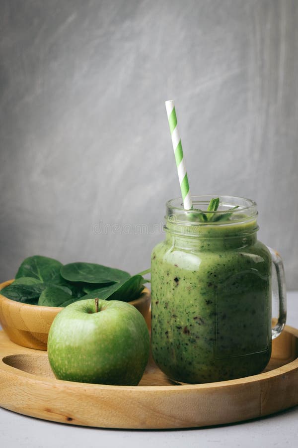 Prima colazione sana, frullato verde in un barattolo di vetro ed alcuni ingredienti - spinaci e mela Superfood, alimento della di fotografia stock Prima colazione sana, frullato verde in un barattolo di vetro ed alcuni ingredienti - spinaci e mela Superfood, alimento della di fotografia stock