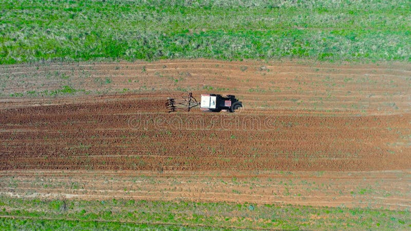 Prima di piantare verdure, un trattore toglie un piccolo campo nel villaggio. vista superiore altezza antenna