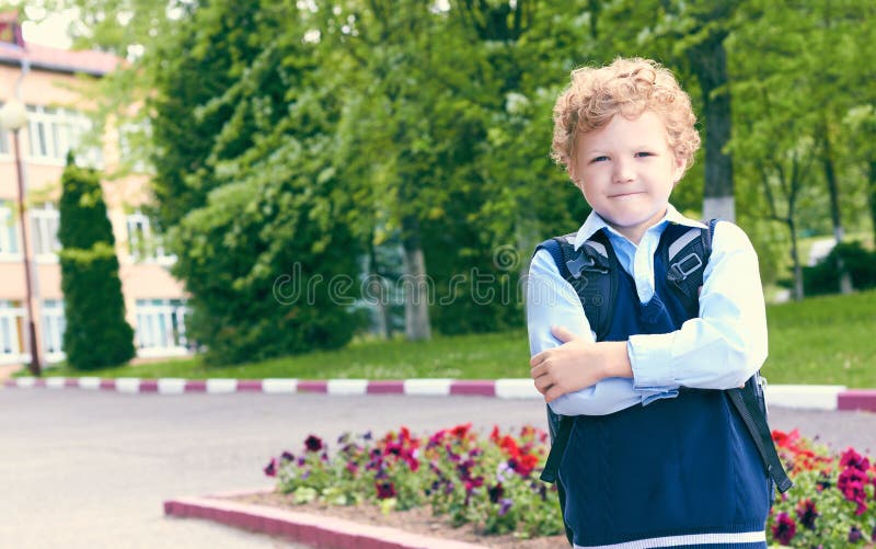 Primary Caucasian School Student Standing Crossarmed Next To His School. Stock Photo Image of