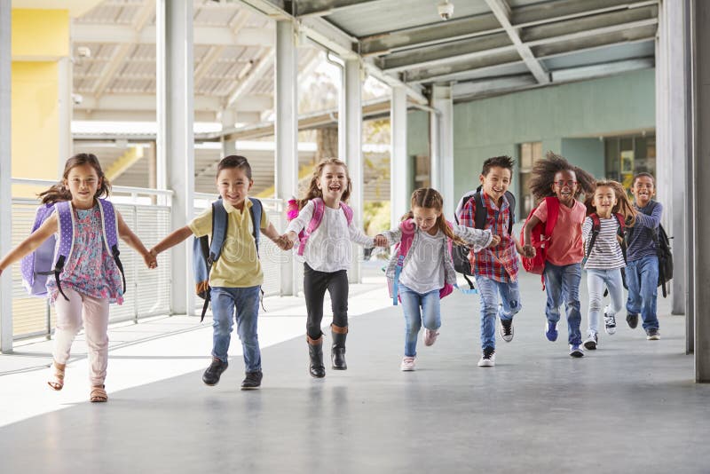 Primary school kids run holding hands in corridor, close up. Happy multiethnic boys stock images, royalty-free photos and pictures