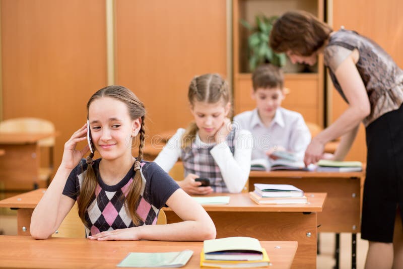 Primary School Pupil Using Cell Phone at Lesson Stock Image - Image of