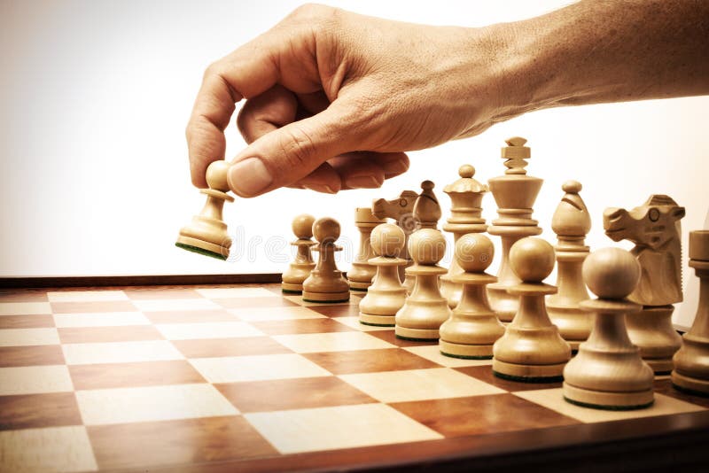 Mão fazendo um movimento com peças de xadrez de madeira no xadrez