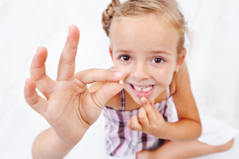 Primeiro leite-dente da menina caído para fora imagens de stock Primeiro leite-dente da menina caído para fora imagens de stock