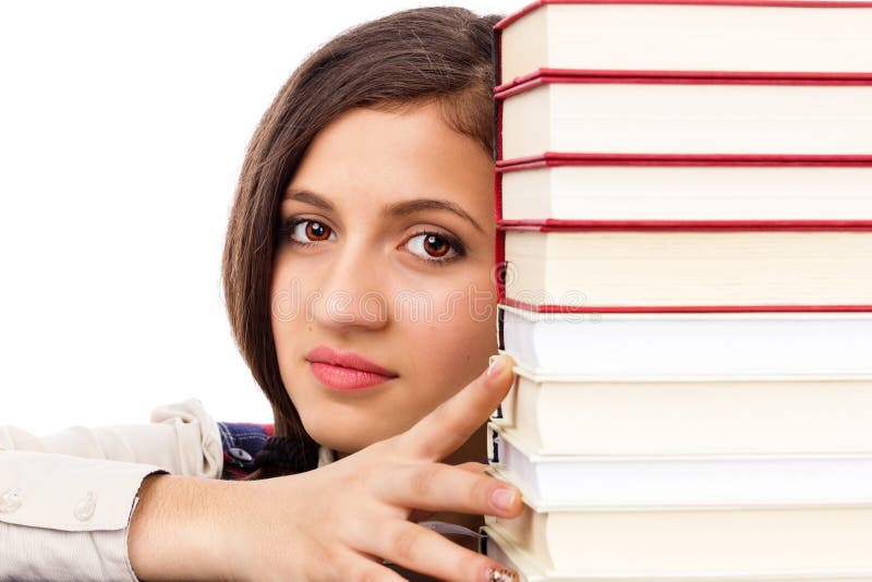 Closeup of student face behind stack of books isolated over white background. Closeup of student face behind stack of books isolated over white background