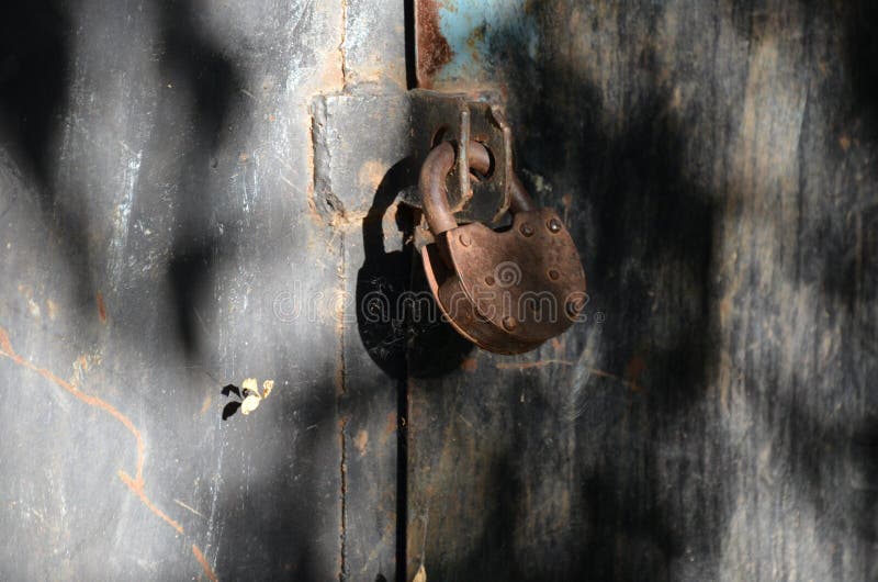 Primer de la cerradura vieja en puerta roja del garaje del metal imagenes de archivo Primer de la cerradura vieja en puerta roja del garaje del metal imagenes de archivo