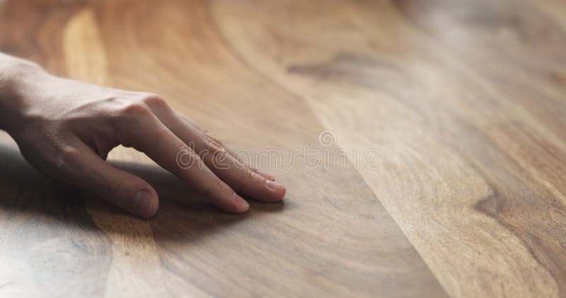 Primer de la mano del hombre que comprueba la superficie de madera dura imagen de archivo Primer de la mano del hombre que comprueba la superficie de madera dura imagen de archivo