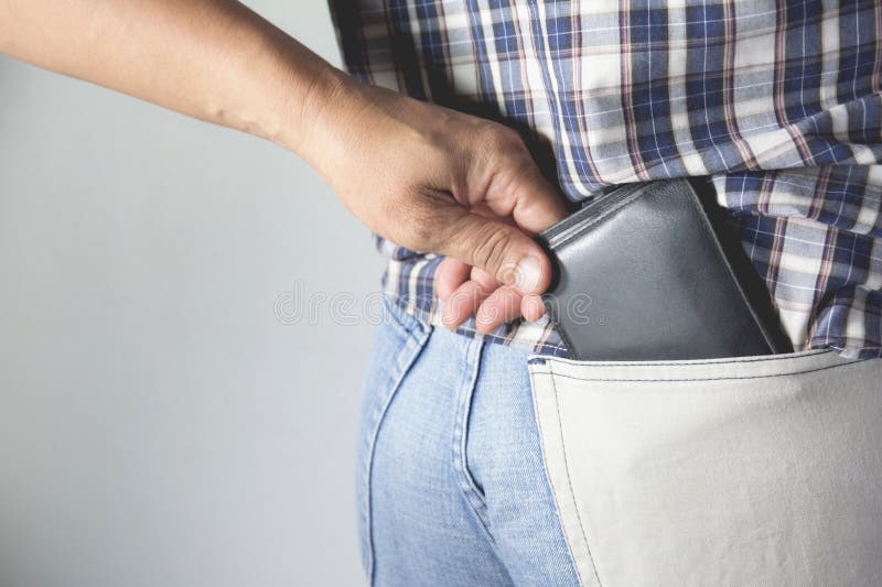 Primer de la mano del ladrón que roba la cartera a una mujer fotografía de archivo libre de regalías Primer de la mano del ladrón que roba la cartera a una mujer fotografía de archivo libre de regalías