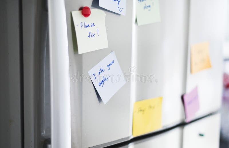 Primer de la nota del papel del recordatorio sobre puerta del refrigerador fotografía de archivo Primer de la nota del papel del recordatorio sobre puerta del refrigerador fotografía de archivo
