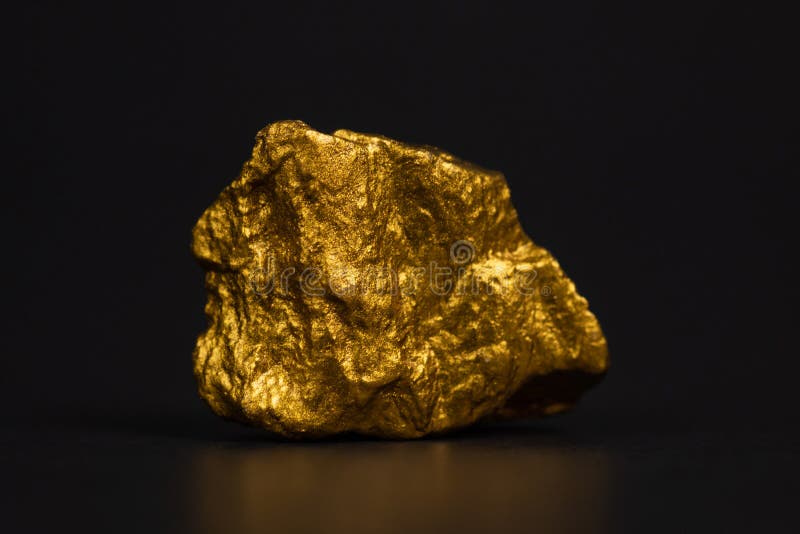 Primer de la pepita de oro o mineral del oro en fondo negro, muy imagen de archivo libre de regalías Primer de la pepita de oro o mineral del oro en fondo negro, muy imagen de archivo libre de regalías