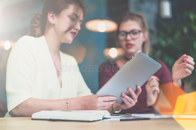 Primer de la tableta en las manos de la empresaria joven que se sientan en la tabla imagen de archivo libre de regalías
