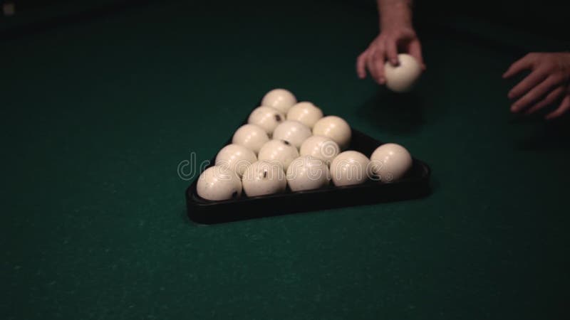 Primer de las bolas de billar dispuestas adulto masculino joven en la tabla verde