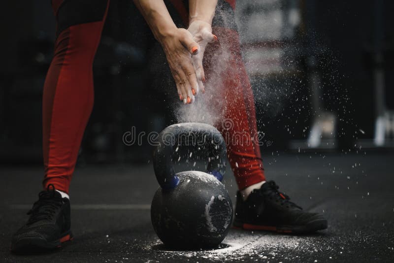 Primer de las manos claping del atleta de sexo femenino del crossfit con la nube del polvo mientras que protección de la magnesia fotos de archivo libres de regalías Primer de las manos claping del atleta de sexo femenino del crossfit con la nube del polvo mientras que protección de la magnesia fotos de archivo libres de regalías