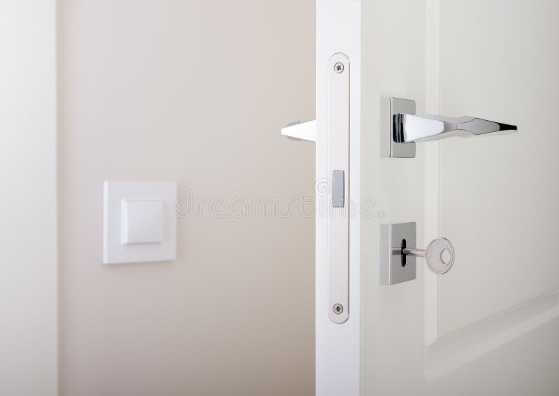 Primer de las puertas interiores blancas Ciérrese con llave y el tirador de puerta del cromo imagen de archivo libre de regalías Primer de las puertas interiores blancas Ciérrese con llave y el tirador de puerta del cromo imagen de archivo libre de regalías