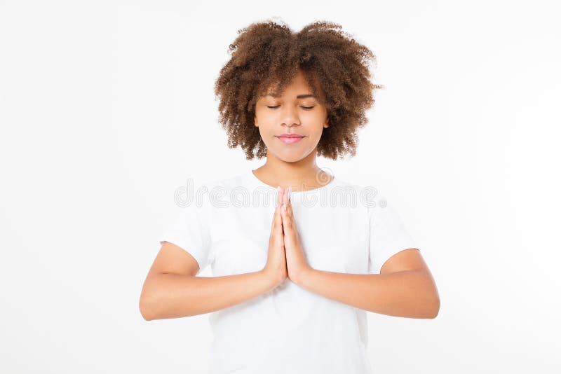 Primer de manos de la mujer negra, afroamericana en la ropa blanca que medita dentro, foco en los brazos en el gesto de Namaste