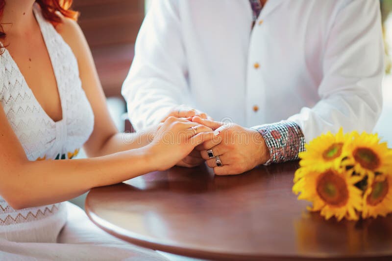 Primer de un hombre que celebra su mano de la esposa en el restaurante foto de archivo libre de regalías Primer de un hombre que celebra su mano de la esposa en el restaurante foto de archivo libre de regalías