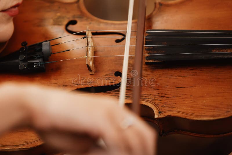 Primer de un violín con un arco Violín de la orquesta de Brown Fingeres en el teclado del violín fotos de archivo libres de regalías Primer de un violín con un arco Violín de la orquesta de Brown Fingeres en el teclado del violín fotos de archivo libres de regalías