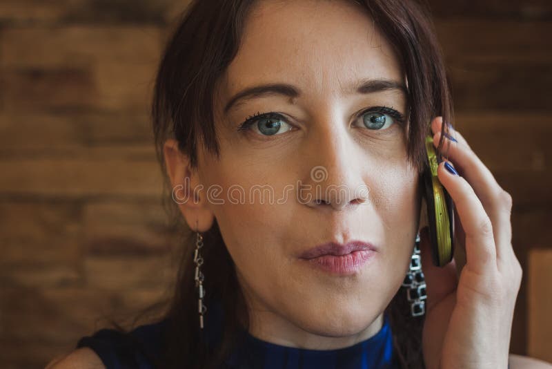 Primer de una muchacha bonita que habla en el teléfono imagen de archivo libre de regalías Primer de una muchacha bonita que habla en el teléfono imagen de archivo libre de regalías