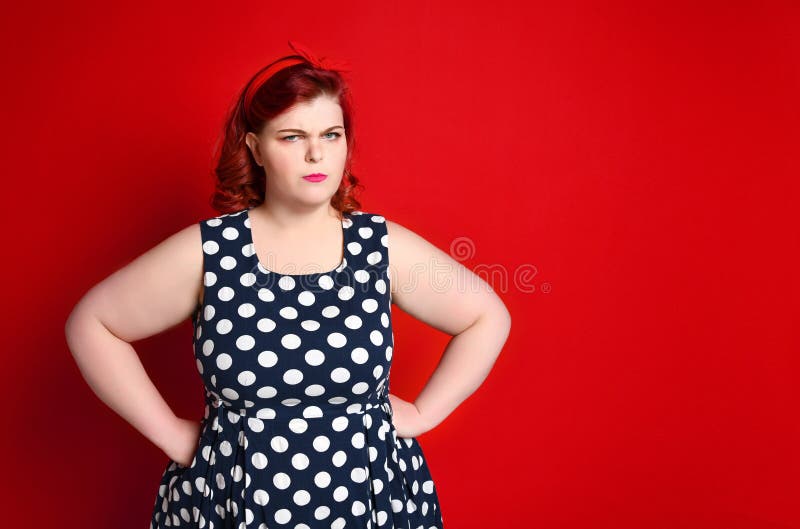 Primer de una mujer enojada gorda del pelirrojo que sostiene su mejilla a mano Muchacha modela aislada foto de archivo Primer de una mujer enojada gorda del pelirrojo que sostiene su mejilla a mano Muchacha modela aislada foto de archivo
