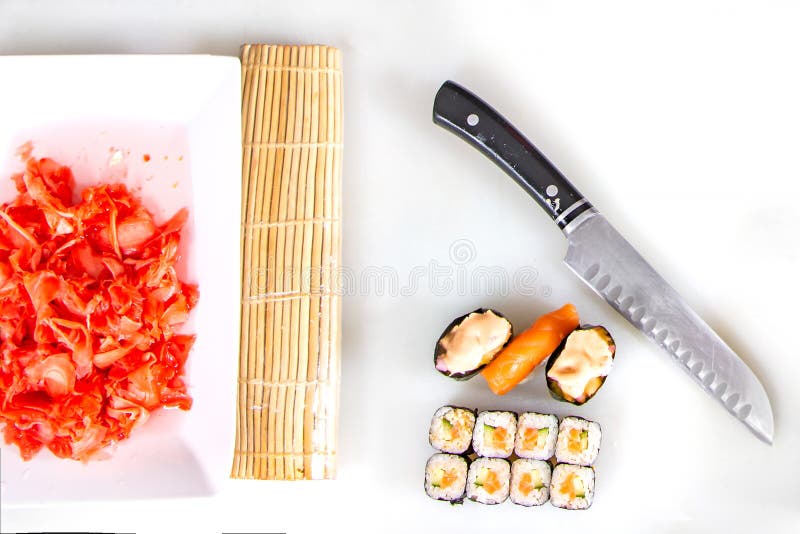 Primer del balanceo encima del sushi en la cocina con el cuchillo y los ingredientes imágenes de archivo libres de regalías Primer del balanceo encima del sushi en la cocina con el cuchillo y los ingredientes imágenes de archivo libres de regalías
