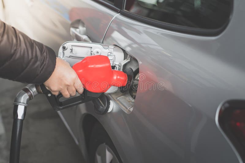 Primer del combustible de bombeo de la gasolina del hombre en coche en la gasolinera imagenes de archivo Primer del combustible de bombeo de la gasolina del hombre en coche en la gasolinera imagenes de archivo