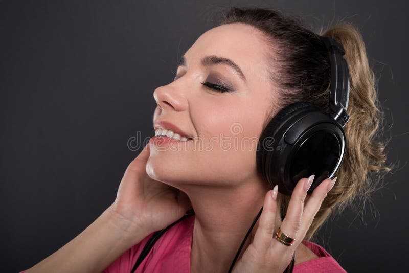 Primer del doctor joven hermoso que escucha los auriculares imagen de archivo Primer del doctor joven hermoso que escucha los auriculares imagen de archivo