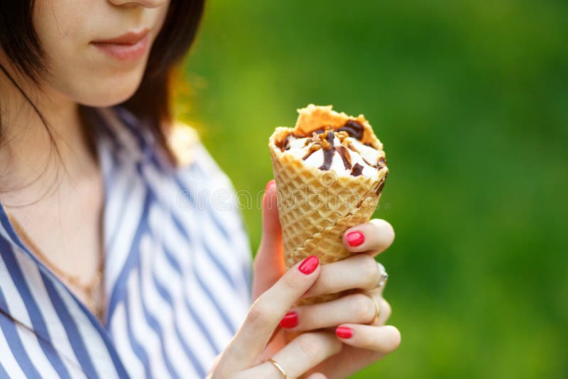 Primer del helado Muchacha hermosa joven con el pelo que fluye largo que sostiene el helado D?a asoleado brillante fotografía de archivo libre de regalías Primer del helado Muchacha hermosa joven con el pelo que fluye largo que sostiene el helado D?a asoleado brillante fotografía de archivo libre de regalías