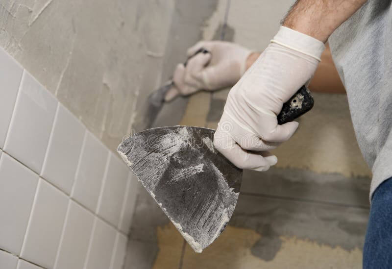 Primer del hombre que embaldosa una pared imágenes de archivo libres de regalías Primer del hombre que embaldosa una pared imágenes de archivo libres de regalías