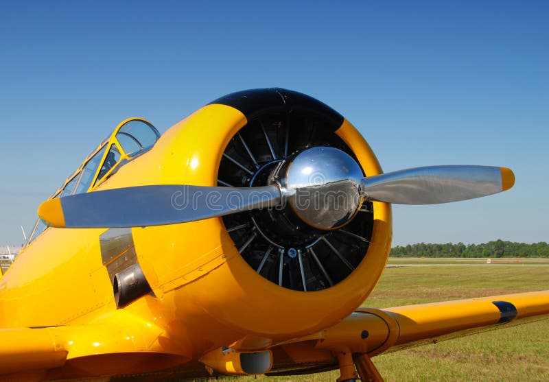 Closeup view of classic propeller airplane parked in field. Closeup view of classic propeller airplane parked in field