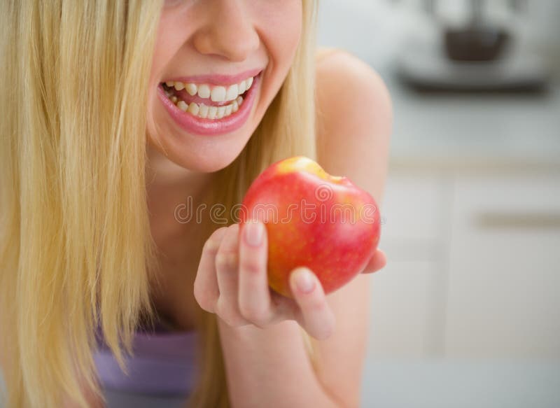 Primer en la muchacha sonriente del adolescente que come la manzana fotografía de archivo Primer en la muchacha sonriente del adolescente que come la manzana fotografía de archivo