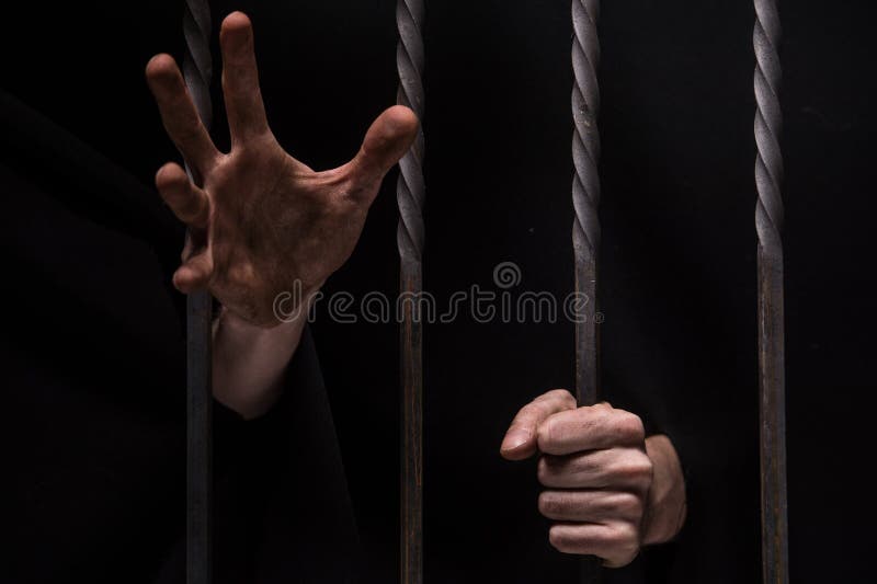 Primer en las manos del hombre que se sientan en cárcel imagen de archivo libre de regalías Primer en las manos del hombre que se sientan en cárcel imagen de archivo libre de regalías