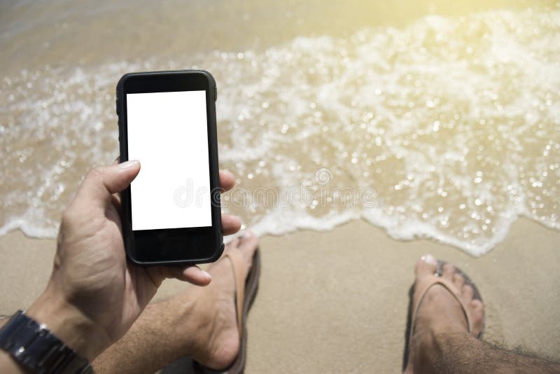 Primer en una mano del hombre que sostiene el teléfono elegante en la playa colocación en la playa fondo exterior Día asoleado Fo imágenes de archivo libres de regalías Primer en una mano del hombre que sostiene el teléfono elegante en la playa colocación en la playa fondo exterior Día asoleado Fo imágenes de archivo libres de regalías