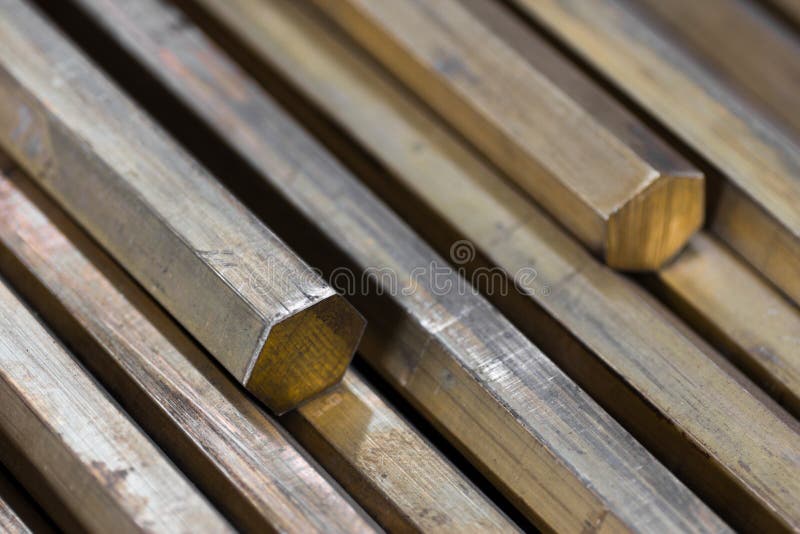 Background of a pile of brass hexagonal rods closeup. Background of a pile of brass hexagonal rods closeup