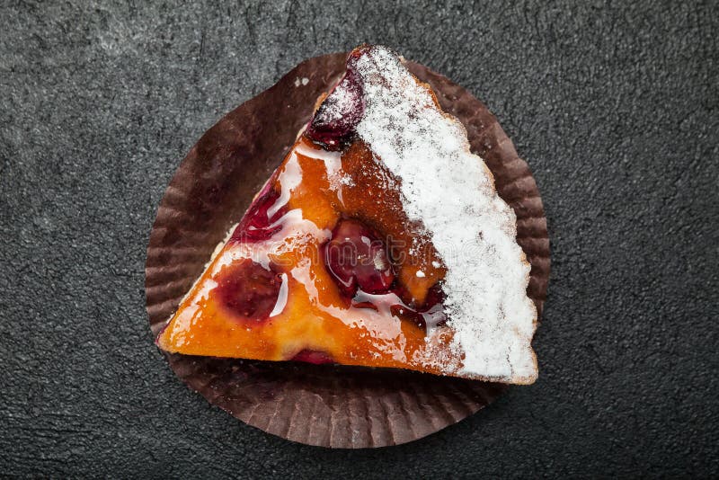 Primer, rebanada una empanada festiva de la fruta en una tabla negra imagen de archivo libre de regalías Primer, rebanada una empanada festiva de la fruta en una tabla negra imagen de archivo libre de regalías
