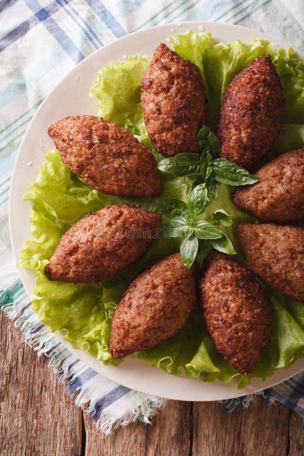 Primo piano arabo del kibbeh delle polpette del manzo su un piatto principale verticale v fotografia stock libera da diritti Primo piano arabo del kibbeh delle polpette del manzo su un piatto principale verticale v fotografia stock libera da diritti