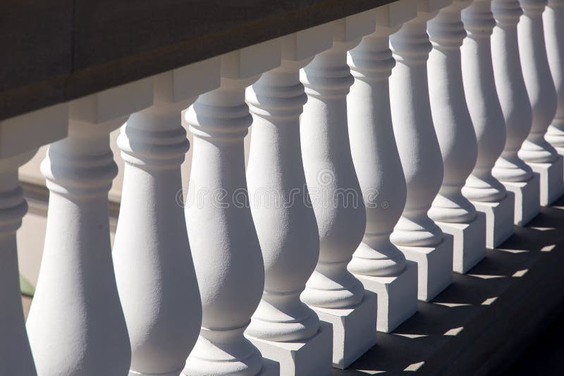 Primo piano bianco di aste della ringhiera della pietra di asta della ringhiera immagine stock libera da diritti Primo piano bianco di aste della ringhiera della pietra di asta della ringhiera immagine stock libera da diritti