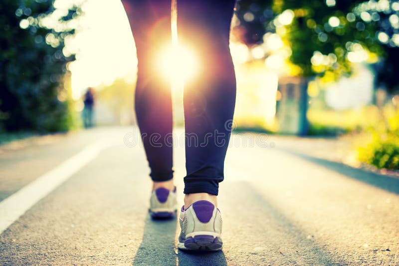 Primo piano dei piedi e delle scarpe di atleta della donna mentre correndo nel parco fotografie stock Primo piano dei piedi e delle scarpe di atleta della donna mentre correndo nel parco fotografie stock