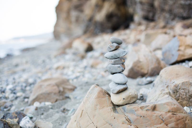 Primo piano del ciottolo che desidera piramide alla spiaggia Immagine della torre di pietra sulla spiaggia fotografie stock