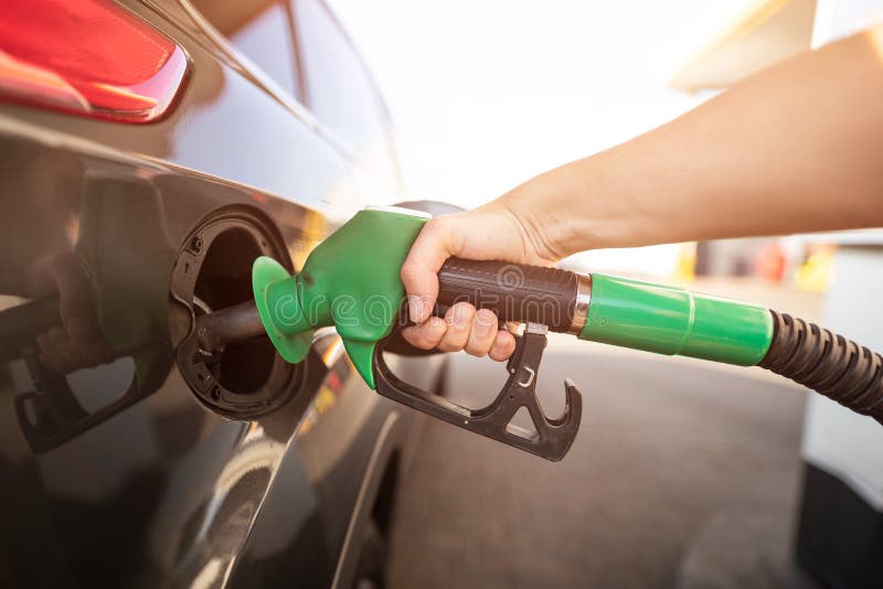 Primo piano del combustibile di pompaggio della benzina dell'uomo in automobile alla stazione di servizio immagini stock Primo piano del combustibile di pompaggio della benzina dell'uomo in automobile alla stazione di servizio immagini stock