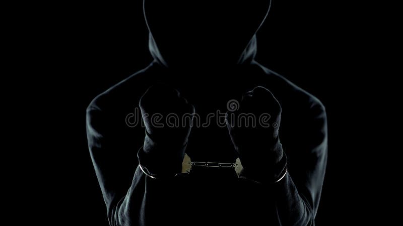 Primo piano del serial killer pericoloso ammanettato, mostrante le mani alla macchina fotografica, punita fotografia stock libera da diritti Primo piano del serial killer pericoloso ammanettato, mostrante le mani alla macchina fotografica, punita fotografia stock libera da diritti